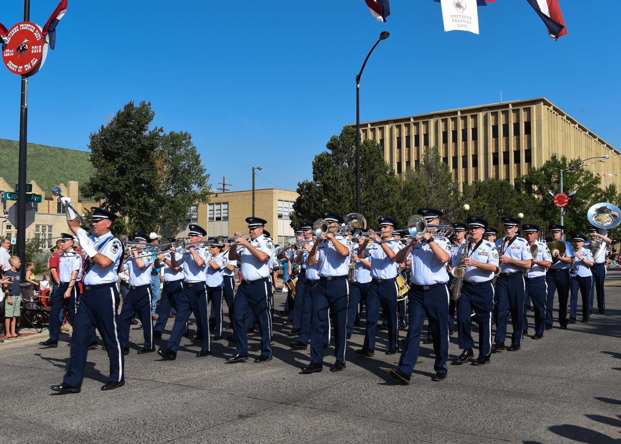 Members of the U.S. Air Force Academy Band play music as they march down the streets of Cheyenne, Wyo., during the 122nd Cheyenne Frontier Days opening Grand Parade, July 21, 2018. Airmen play many roles in making CFD, the biggest event in Cheyenne, a success. The two communities came together to celebrate during the 122nd CFD rodeo and festival. (U.S. Air Force photo by Airman 1st Class Abbigayle Wagner)