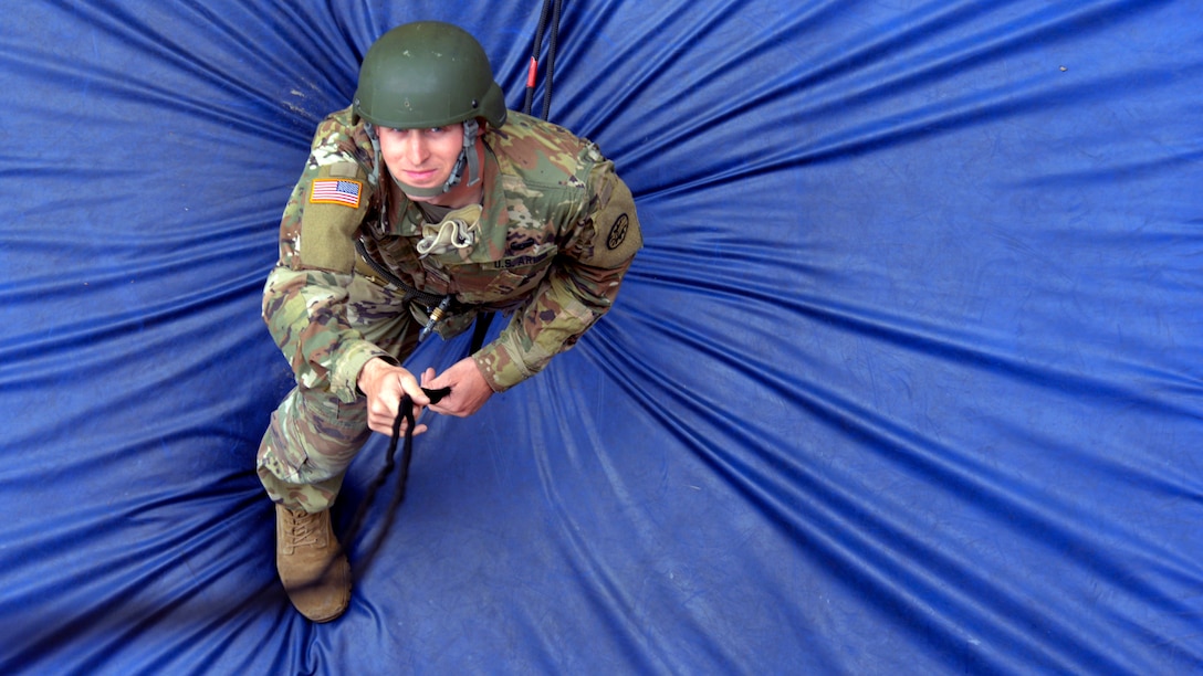 A soldier stands on a blue pad.