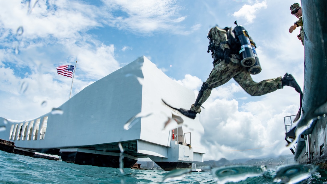 A scuba diver jumps into the water.