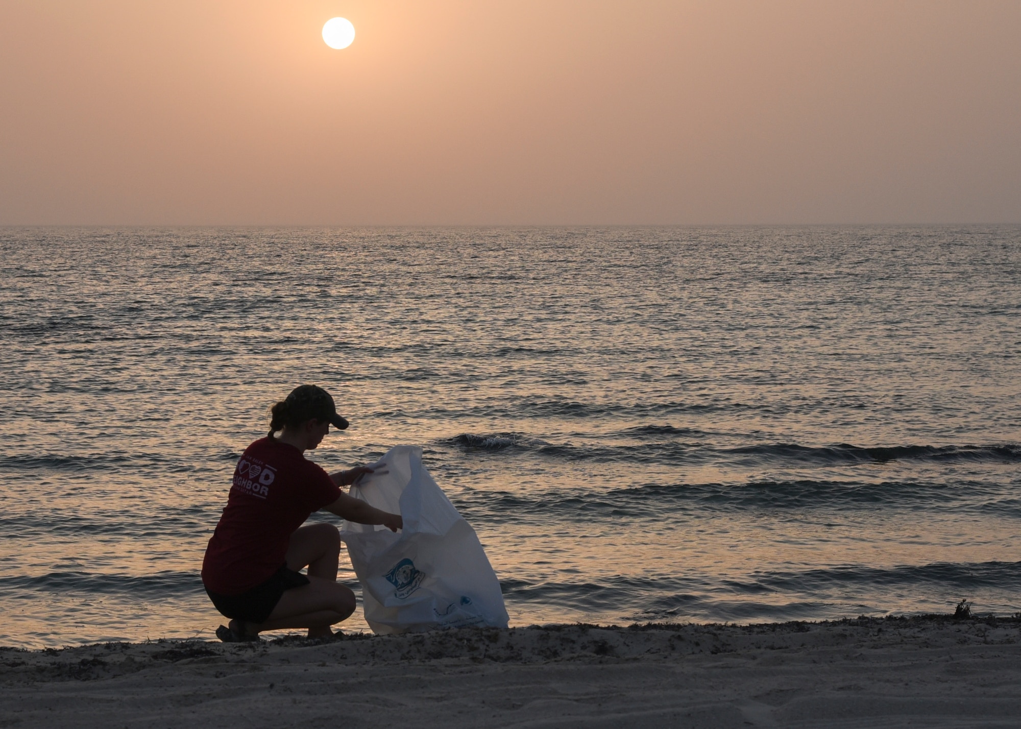 Staff Sgt. Brittani McClure, president of Jar Saleh, a volunteer organization at Al Udeid Air Base, picks up trash during a trip to clean up beaches in Doha, Qatar, July 6, 2018. Jar Saleh works alongside the host nation’s community groups to continue a good-faith relationship through acts of kindness and generosity. (U.S. Air Force photo by Staff Sgt. Enjoli Saunders)
