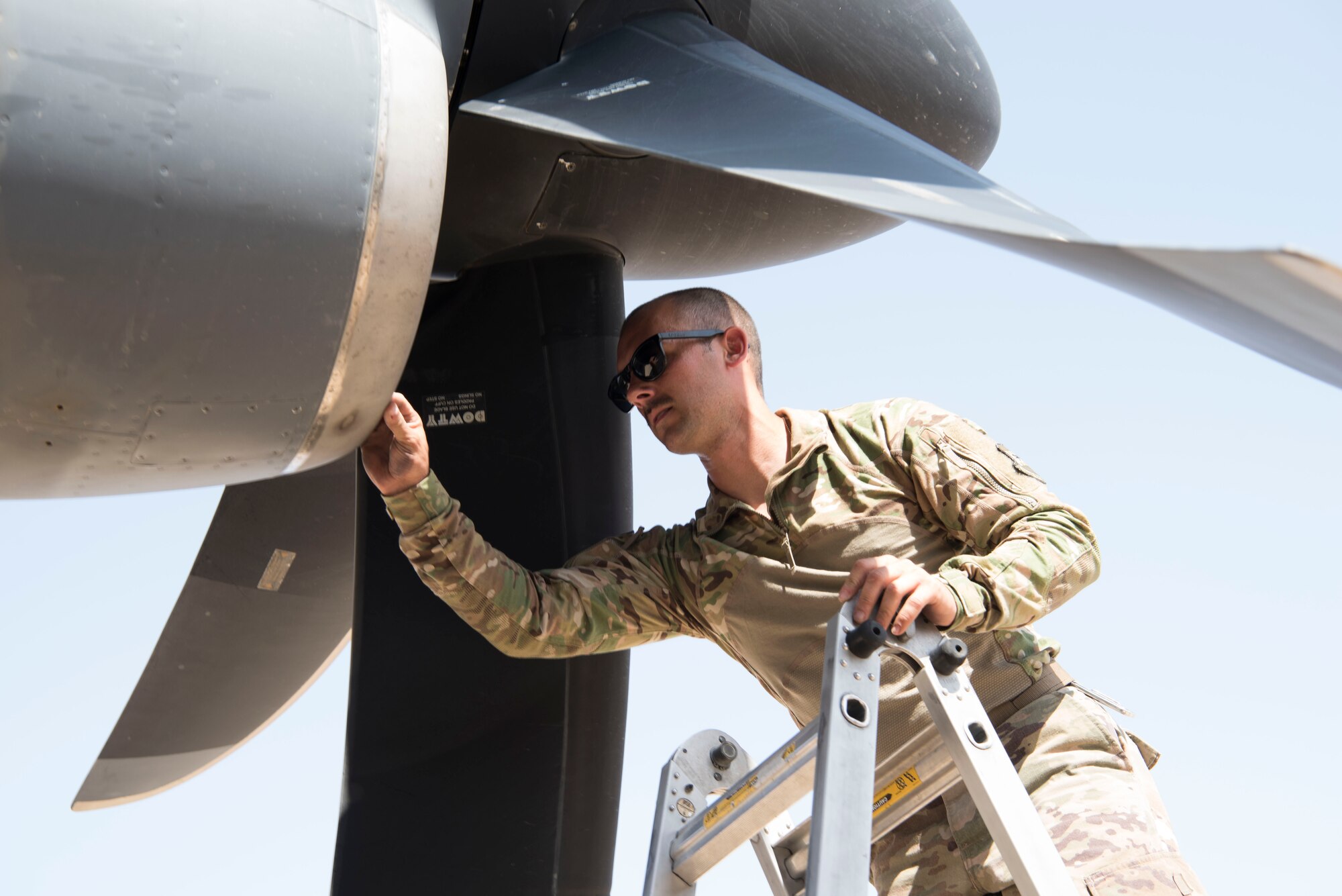 An Airman with the 801st Expeditionary Maintenance Squadron performs post-flight checks and maintenance on a C-130 Hercules, July 4, 2018, at Al Asad Air Base, Iraq.
