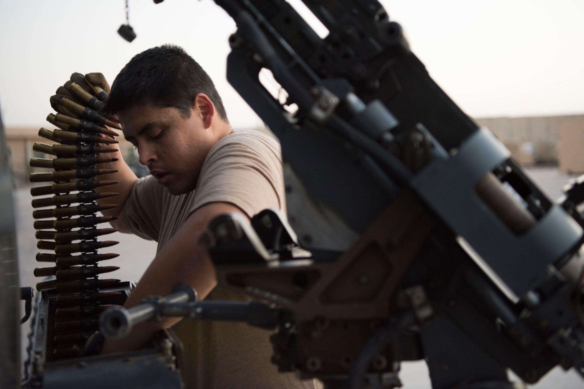 An Airman with the 801st Expeditionary Maintenance Squadron loads an HH-60 Pave Hawk’s machine gun with training rounds for a nighttime exercise, July 4, 2018, at Al Asad Air Base, Iraq.