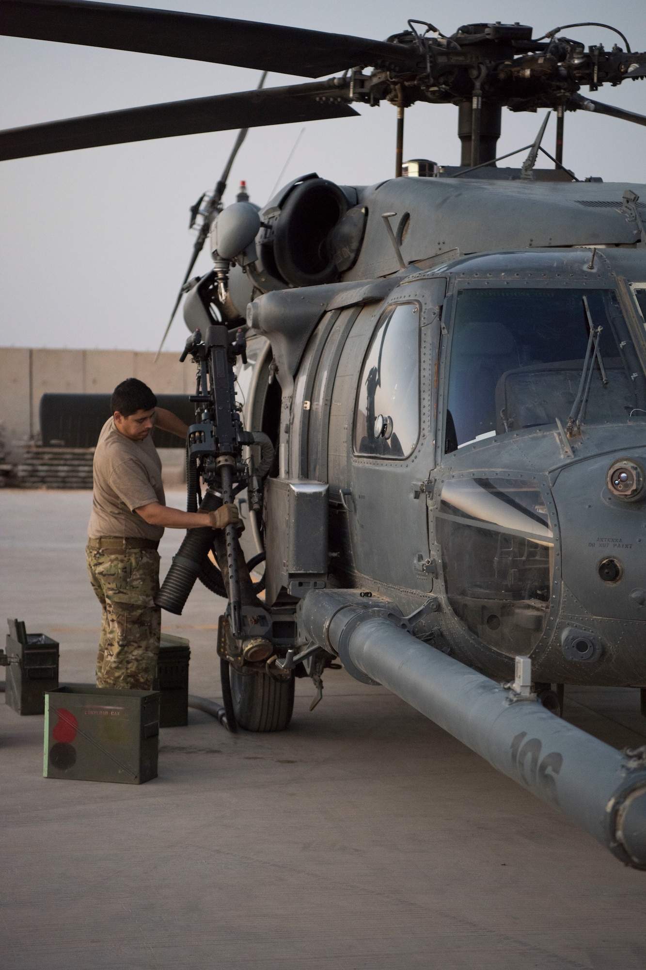 An Airman with the 801st Expeditionary Maintenance Squadron loads an HH-60 Pave Hawk’s machine gun with training rounds for a nighttime exercise, July 4, 2018, at Al Asad Air Base, Iraq.