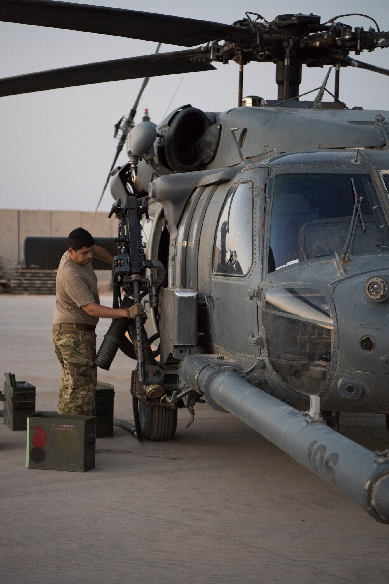 An Airman with the 801st Expeditionary Maintenance Squadron loads an HH-60 Pave Hawk’s machine gun with training rounds for a nighttime exercise, July 4, 2018, at Al Asad Air Base, Iraq.