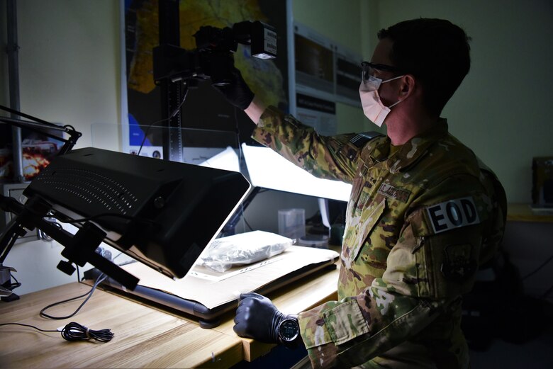 Master Sgt. Michael Breive, Forensic Exploitation Laboratory – CENTCOM non-commissioned officer in charge, prepares to photograph a piece of evidence June 27, 2018 at the FXL-C lab, located on Camp Arifjan, Kuwait. Breive is the sole Airman at the FXL-C office, serving in a joint expeditionary tasked and individual augmentee role. (U.S. Air Force photo by Staff Sgt. Christopher Stoltz)