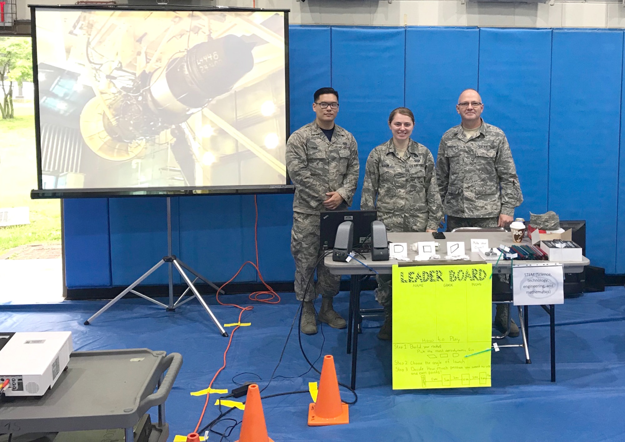 2nd Lt. Jimyung Park, 2nd Lt. Ashley Olson, Senior Master Sgt. Darrell Townsend man their booth at the Osan Science, Technology, Engineering and Mathematics (STEM) Career Day held for students of military families at the base in South Korea. As part of the STEM event, Townsend, who is a craft superintendent at Arnold Air Force Base in addition to serving in the Tennessee Air National Guard, helped demonstrate how to launch straw rockets. The materials for the demonstration were provided by Olga Oakley, Air Force STEM director at Hands-On Science Center. (Courtesy photo)
