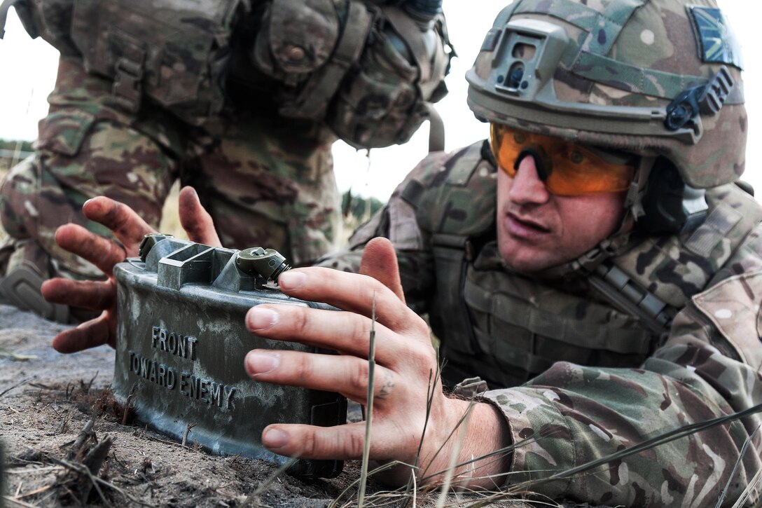 A British soldier emplaces an M18A1 Claymore mine.