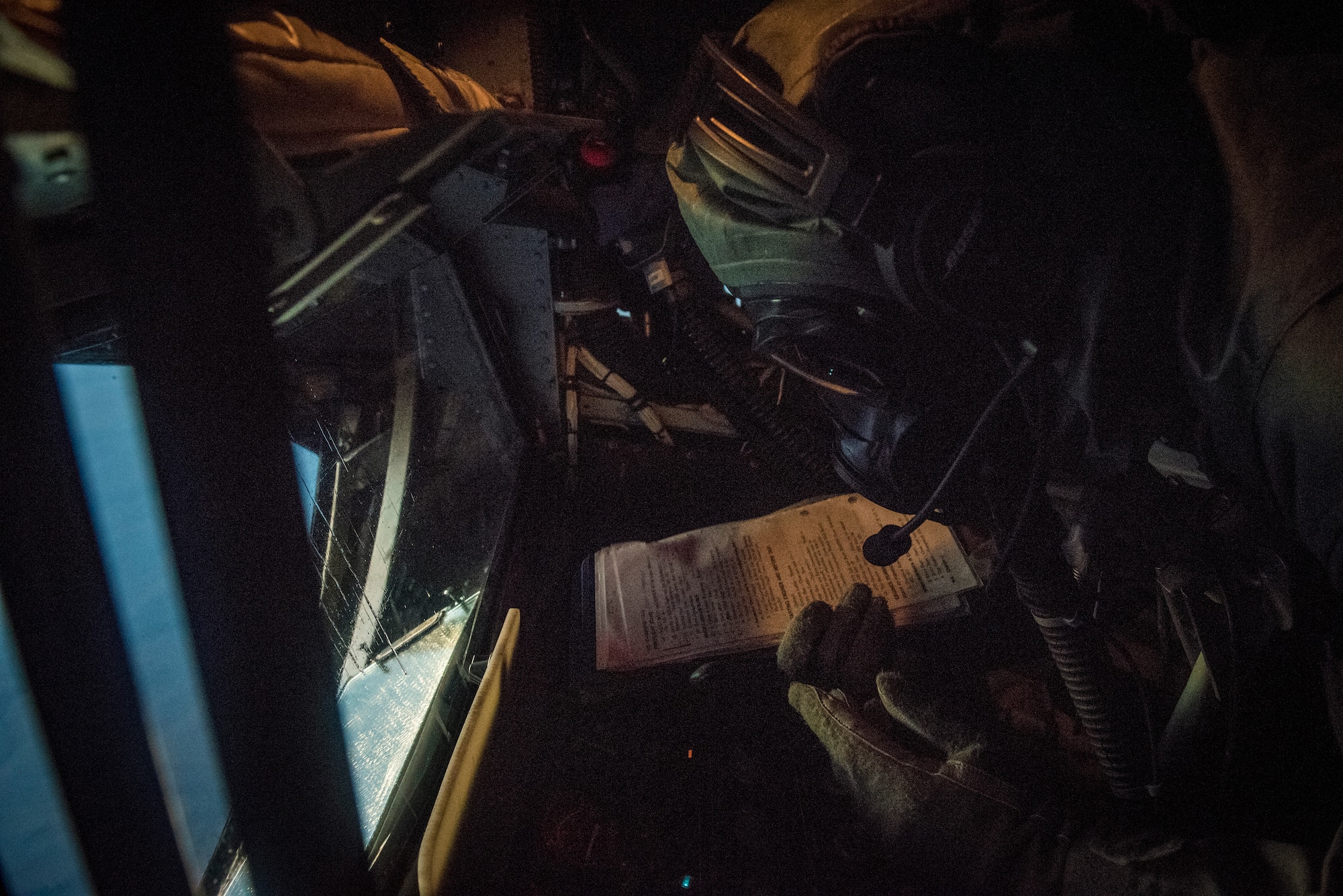 Airman 1st Class Jeremiah Guinto, 92nd Air Refueling Squadron boom operator, reviews a task checklist during the first in-field use and test of the new Joint Service Aircrew Mask on a KC-135 at Fairchild Air Force Base, Washington, July 17, 2018. The development of the JSAM contributes to the continuous investments in Mobility Air Force capabilities and readiness, which is essential to ensuring the Air Force maintains range, speed and agility advantages over potential adversaries, and in support of global mobility operations. (U.S. Air Force photo/ Airman 1st Class Whitney Laine)