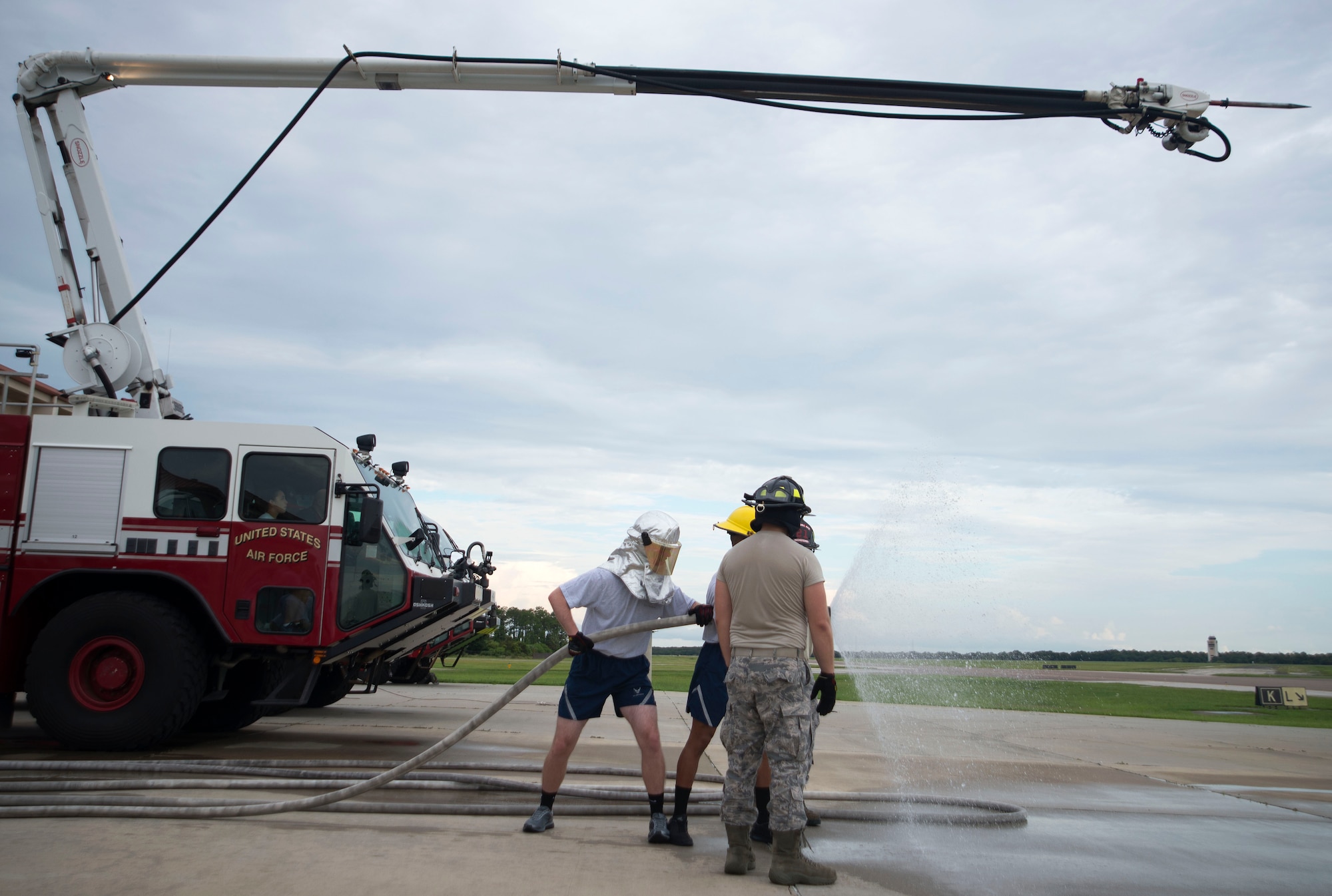 U.S. Air Force Fire Protection Airmen with the 6th Civil Engineer Squadron assist cadets operating a fire hose at the Crash Fire Station on MacDill Air Force Base, Fla., July 6, 2018.