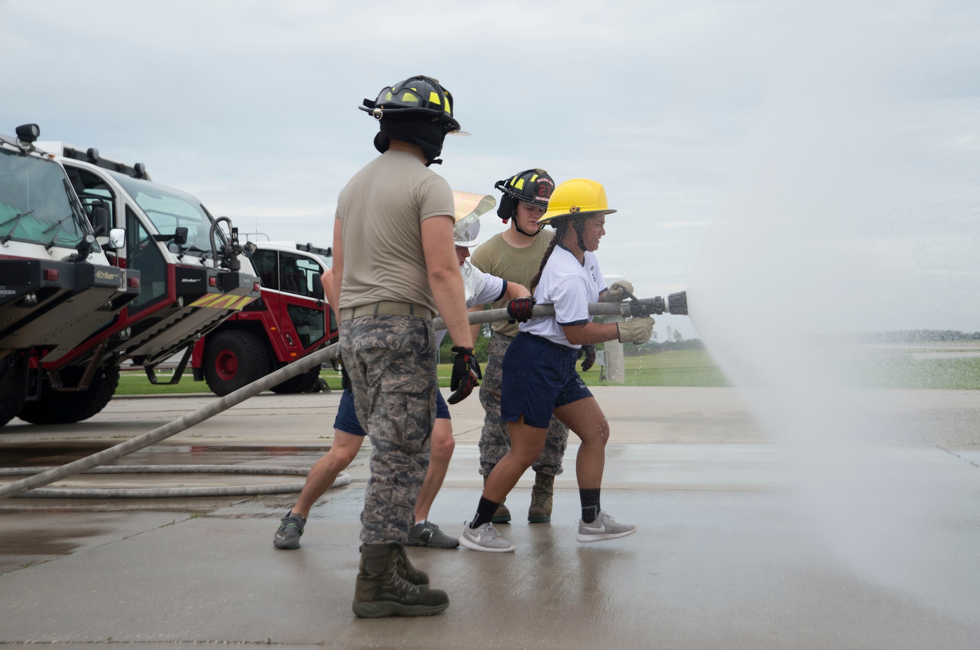 U.S. Air Force Fire Protection Airmen with the 6th Civil Engineer Squadron assist cadets in operating a fire hose at the Crash Fire Station on MacDill Air Force Base, Fla., July 6, 2018.