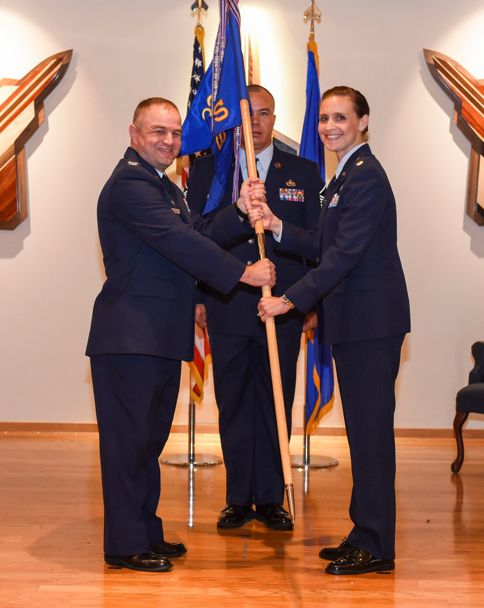 U.S. Air Force Col. Matthew Jefson, 325th Mission Support Group commander, left, passes the ceremonial guidon to Maj. Sarah Bowles, incoming 325th Logistics Readiness Squadron commander, right, during an assumption of command ceremony at Tyndall Air Force Base, Florida, July 20, 2018.