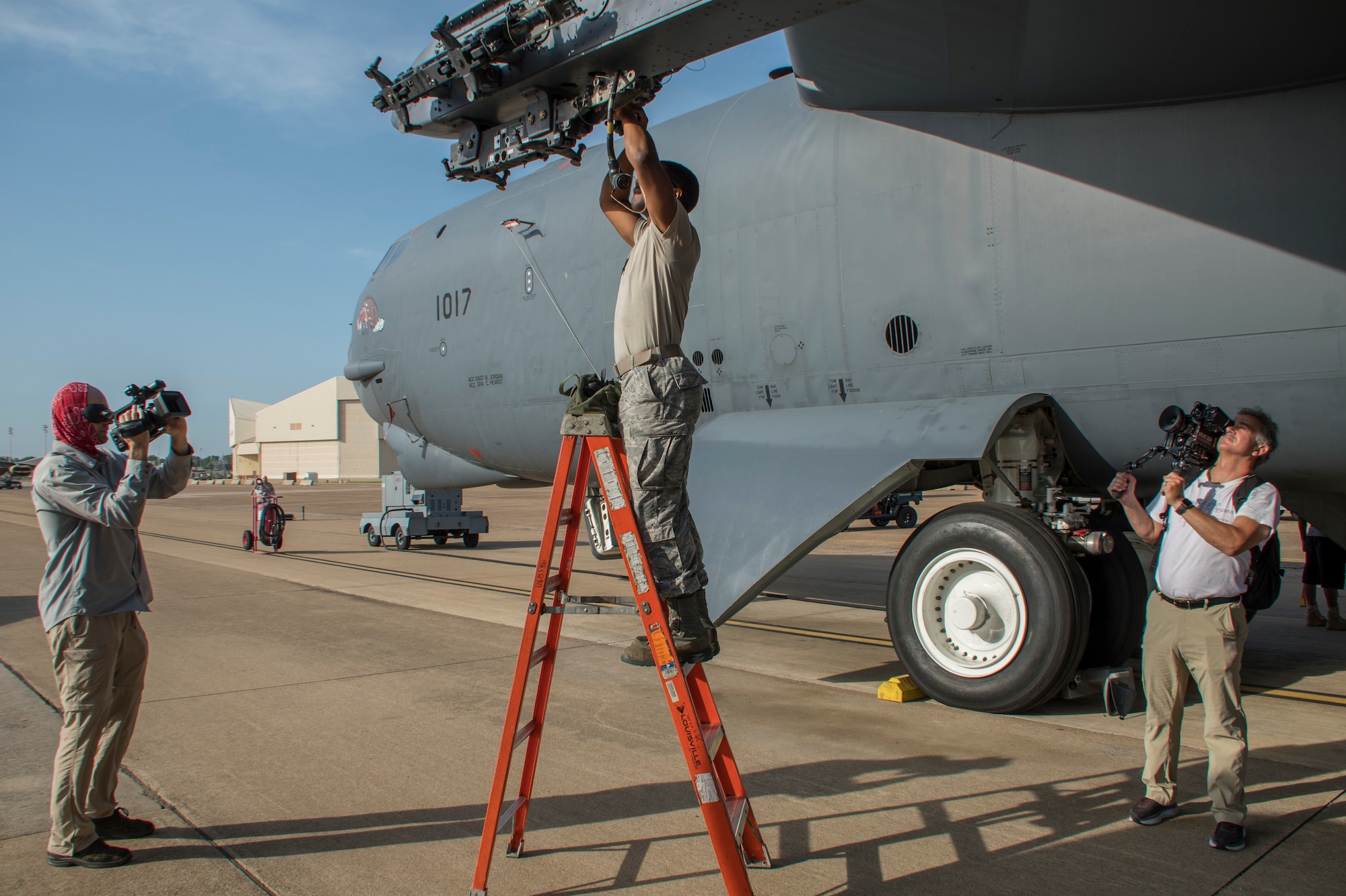 Chris Riggs and Tom LaRochelle, advanced media specialists from the Raytheon Company, film an Airman assigned to the 307th Aircraft Maintenance Squadron preparing a Heavy Storage Adaptor Beam on a B-52 Stratofortress at Barksdale Air Force Base, Louisiana, July 20, 2018. Media specialists from Raytheon gathered footage of the preparation and loading of Raytheon’s MALD-X missile on the beam. (U.S. Air Force photo by Airman Maxwell Daigle/Released)