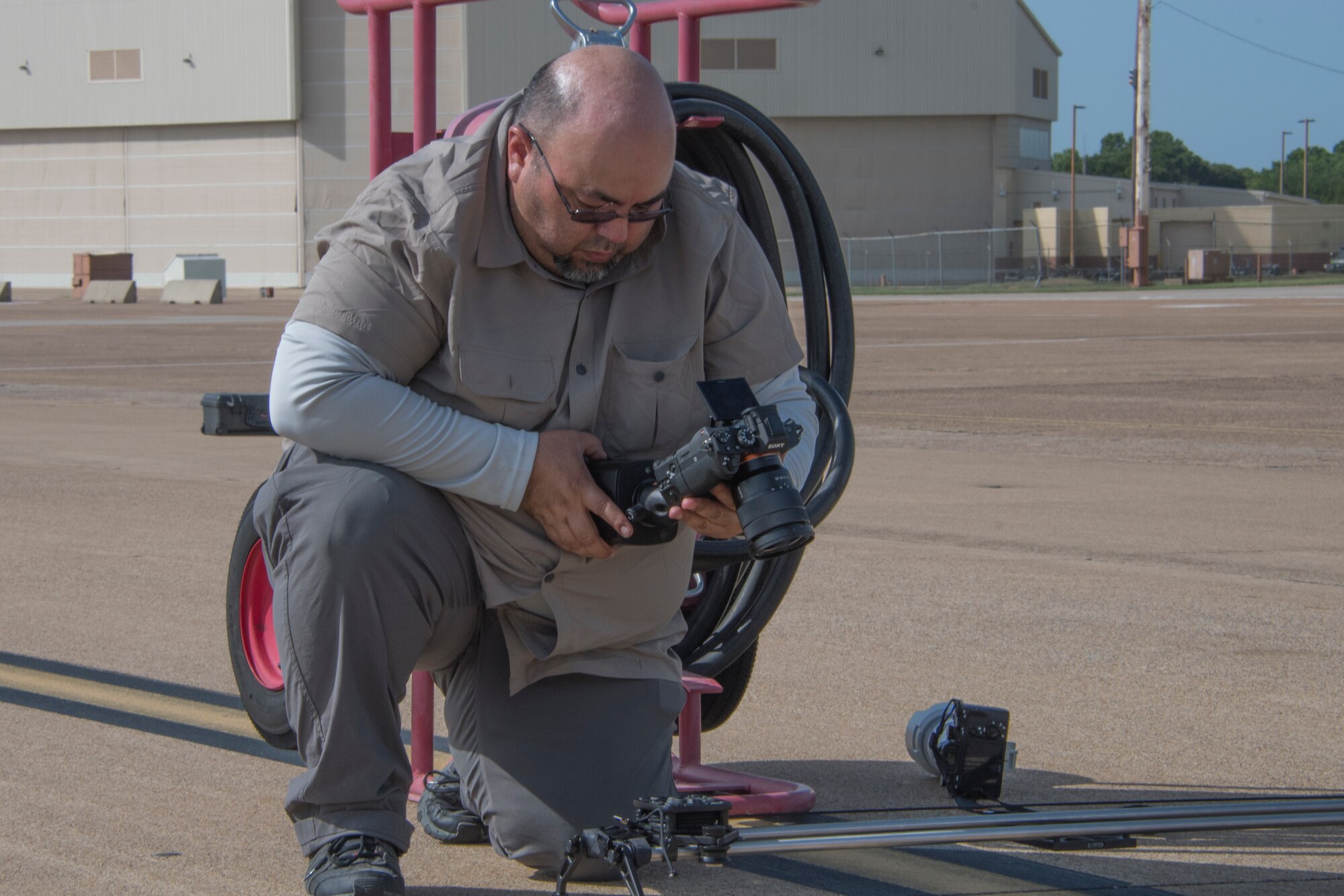 Ronn Trevino, an advanced media specialist from the Raytheon Company, checks his camera at Barksdale Air Force Base, Louisiana, July 20, 2018. Trevino and other media specialists from Raytheon were gathering footage during the preparation and loading of Raytheon's MALD-X missiles on a B-52 Stratofortress. The 307th Aircraft Maintenance Squadron supported the effort. (U.S. Air Force photo by Airman Maxwell Daigle/Released)