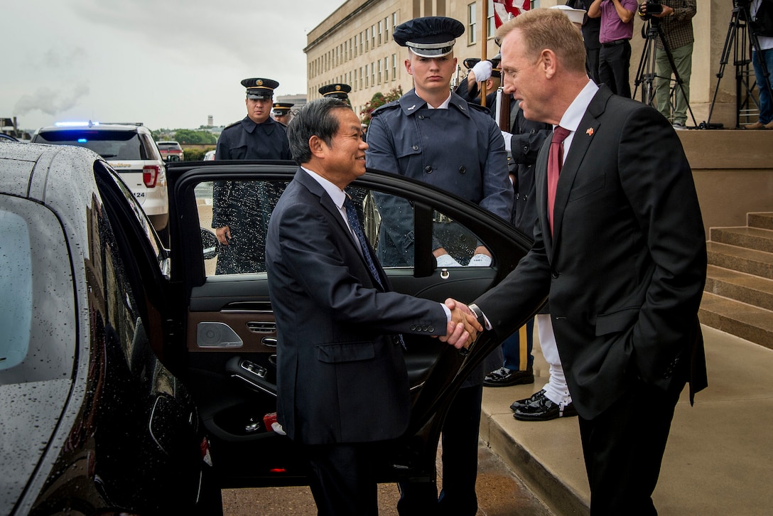 Deputy Defense Secretary Patrick M. Shanahan greets a visitor in front of the Pentagon.