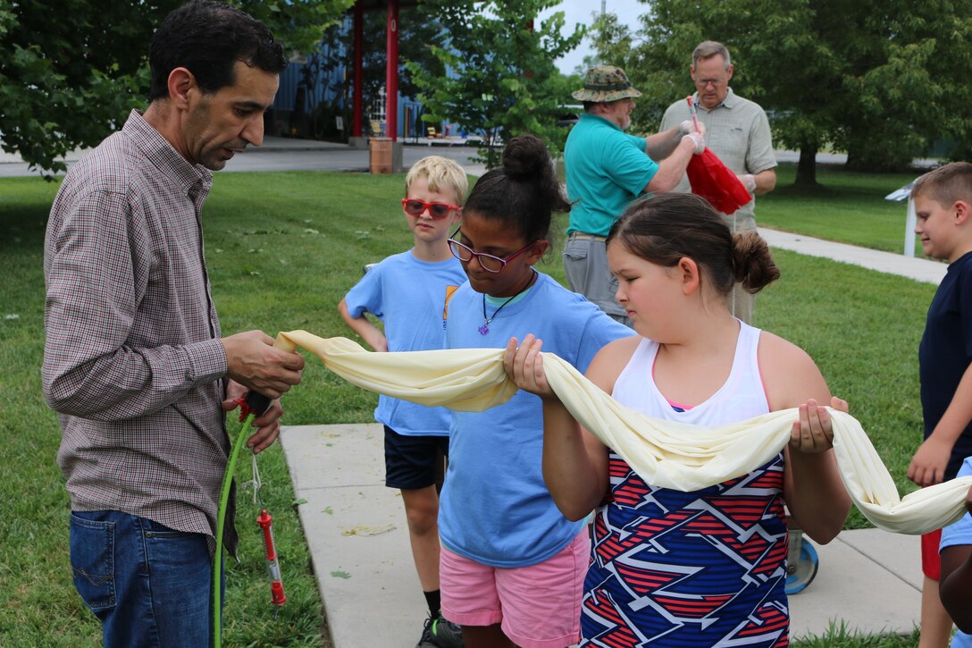 Younes Baalla, a recent graduate from the University of Tennessee Space Institute, left, gets a helping hand as he prepares to inflate a high-altitude balloon. The balloon was launched June 19 as part of the Hands-On Science Center Air STEM Summer Camp. (U.S. Air Force photo/Bradley Hicks)