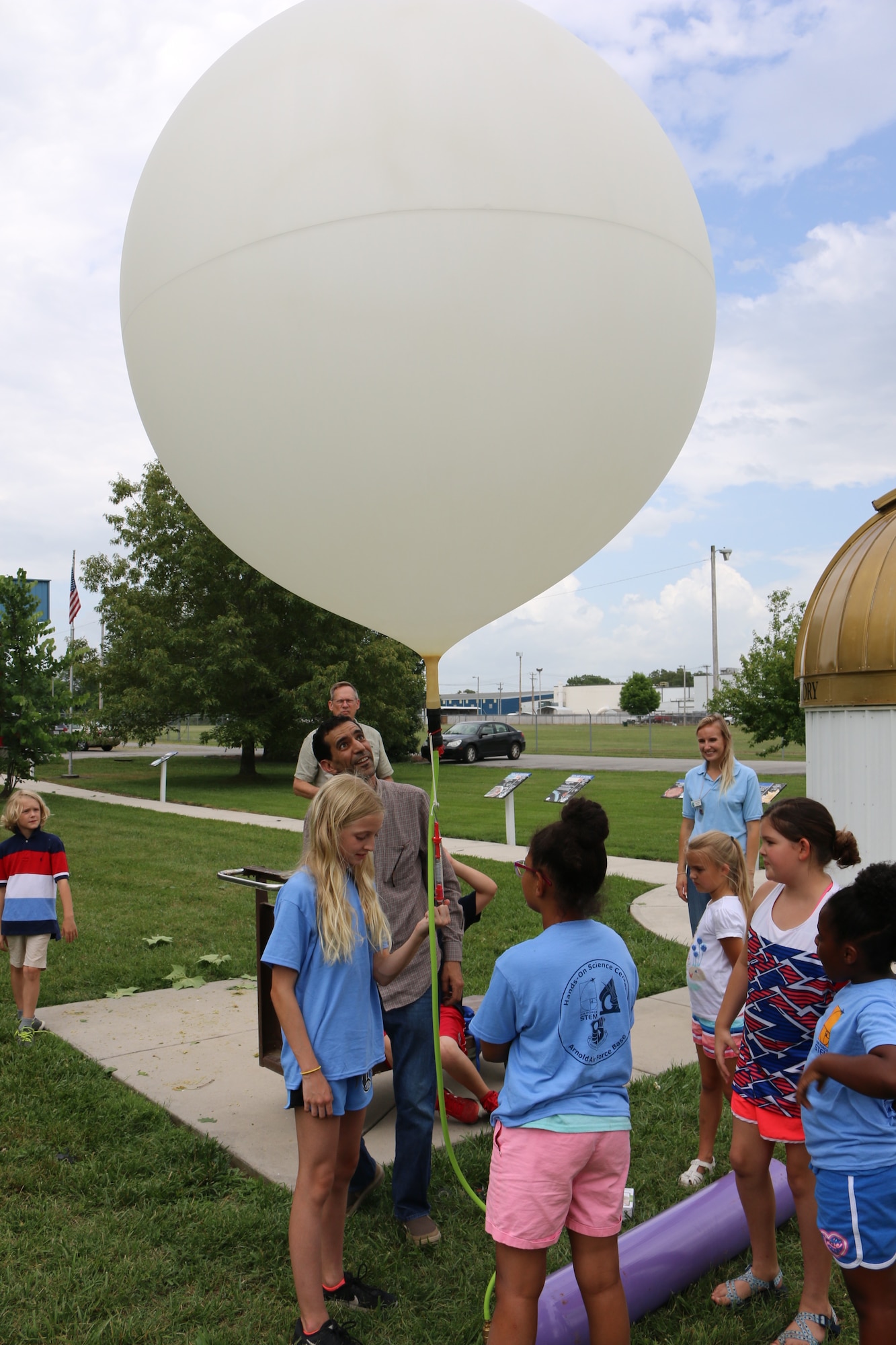 Participants in the Hands-On Science Center Air Force STEM Summer Camp offer a helping hand as a high-altitude balloon prepares for launch. The balloon was launched on June 19 from the grounds of the HOSC as part of the Summer Camp program. (U.S. Air Force photo/Bradley Hicks)