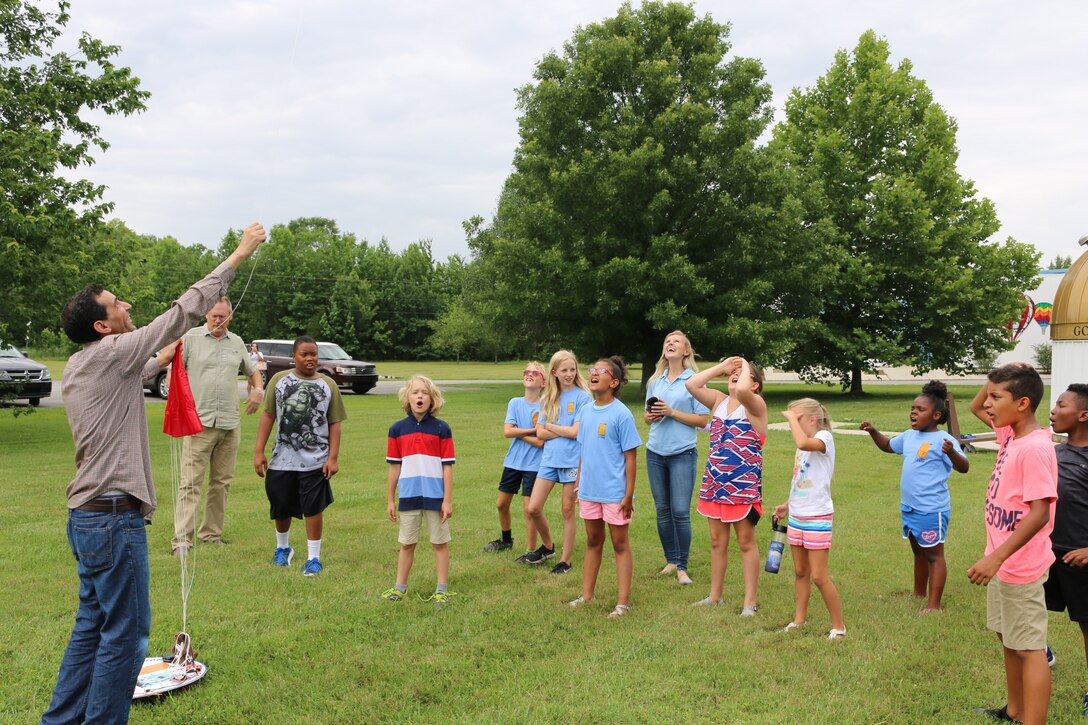Younes Baalla, a recent University of Tennessee Space Institute graduate, left, prepares to release a high-altitude balloon as the countdown from participants in the Hands-On Science Center Air Force STEM Summer Camp reaches zero. The balloon was launched on June 19 from the grounds of the HOSC as part of the Summer Camp program. (U.S. Air Force photo/Bradley Hicks)