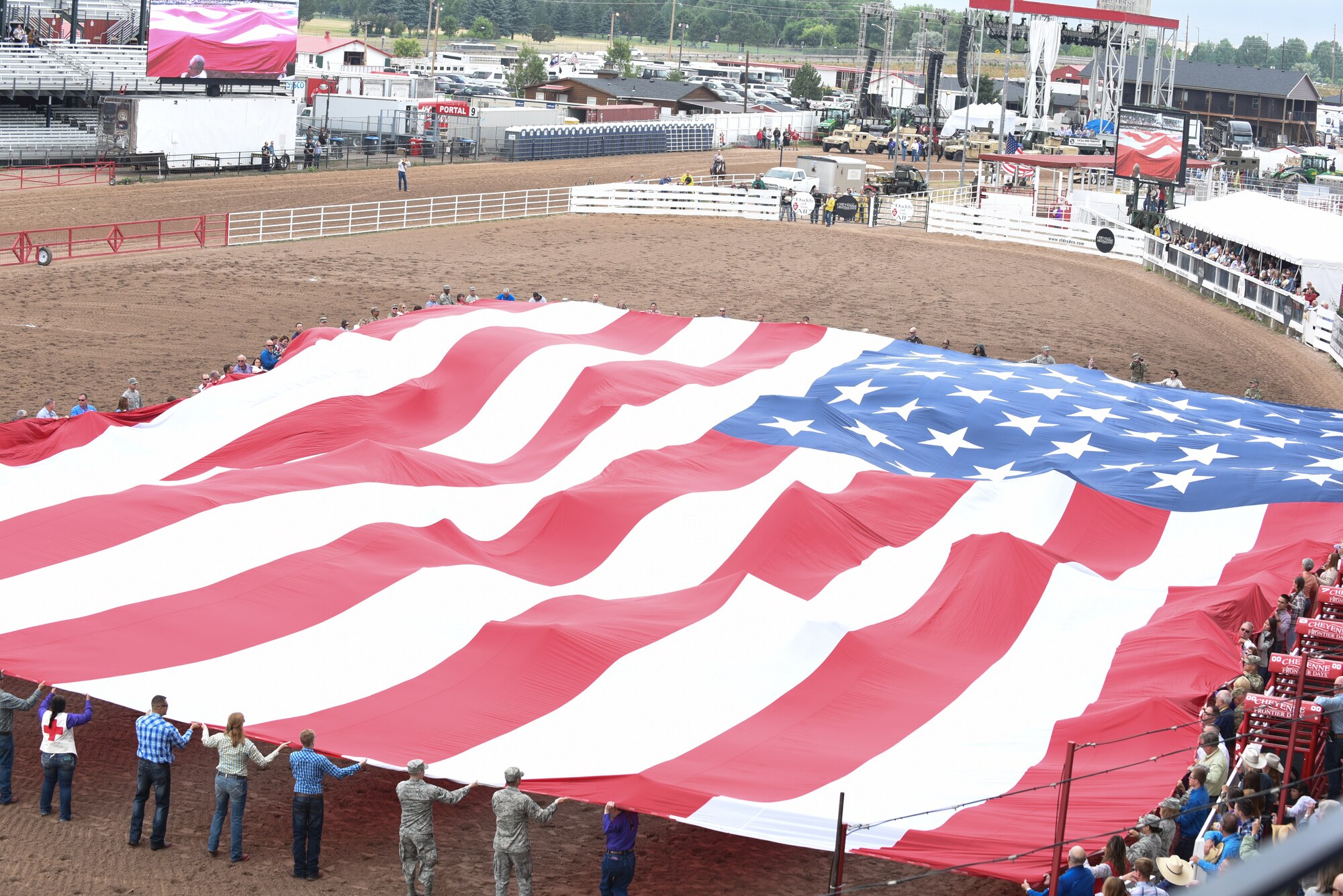 Members of the military and local community present the American flag during Military Monday at Frontier Park in Cheyenne, Wyo., July 23, 2018. The flag presentation is an annual tradition at Cheyenne Frontier Days. The Airmen’s involvement during CFD provides an opportunity to showcase the strong relationship between the base and the local community. (U.S. Air Force photo by Airman 1st Class Abbigayle Wagner)