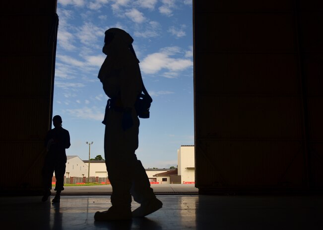 Staff Sgt. Brian Groll, 375th Aeromedical Evacuation technician out of Scott Air Force Base Ill. walks through a hangar at Joint Base Charleston, S.C. July 18, 2018. Groll donned necessary personal protective equipment during an exercise dealing with the transport of highly infectious patients.