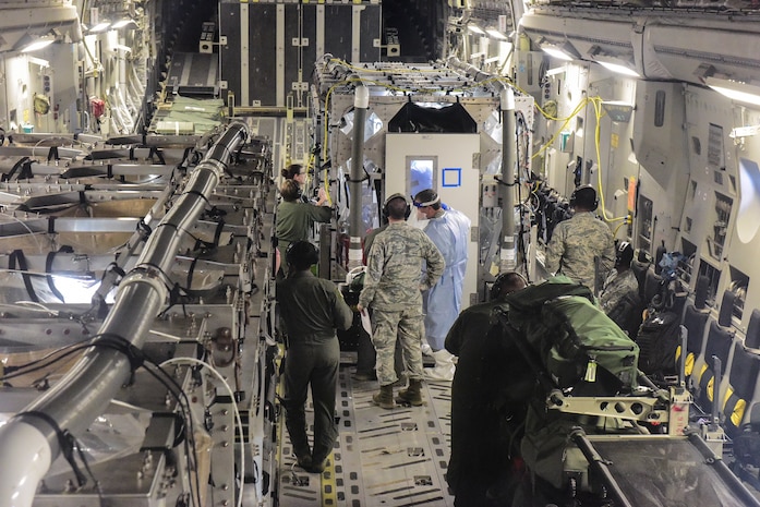 Airmen from the 628th and 375th Aeromedical Evacuation Squadrons out of Joint Base Charleston, S.C. and Scott Air Force Base Ill., along with medical researchers from Indiana and Nebraska universities conduct Transportation Isolation System training July 18, 2018 on a flight from Joint Base Charleston to Offutt Air Force Base, Neb. The Transport Isolation System, or TIS, is an enclosure the Department of Defense can use to safely transport patients with highly contagious diseases such as Ebola.