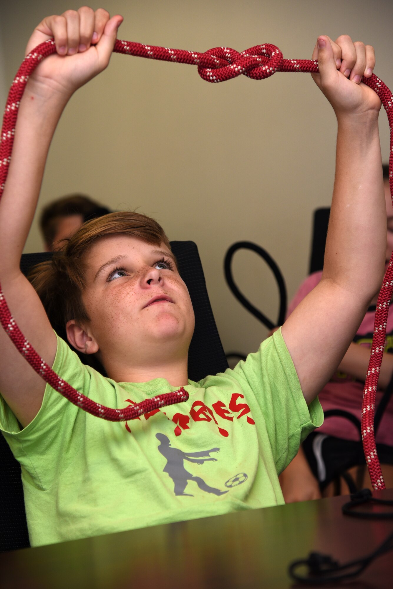 Junior firefighter, Nate Henry, holds up a knot during the Junior Firefighter Camp at the Fire Station on Goodfellow Air Force Base, Texas, July 18, 2018. Henry and the other junior firefighters learned to tie several knots used for various situations. (U.S. Air Force photo by Staff Sgt. Joshua Edwards/Released)