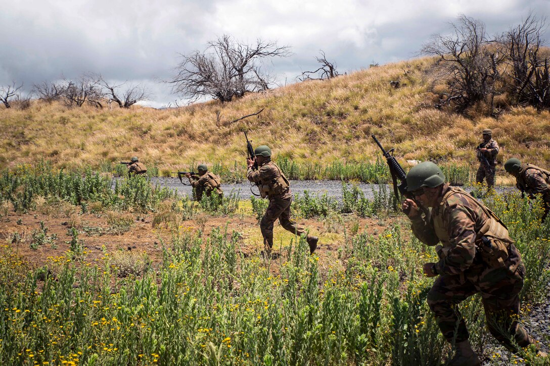 Tongan marines maneuver toward mock enemies during a live-fire training event.