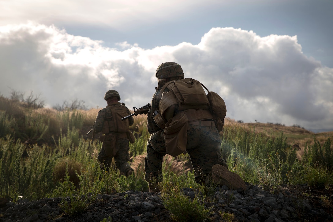 Marines rush up a hill to secure a notional enemy position during a live-fire training event.