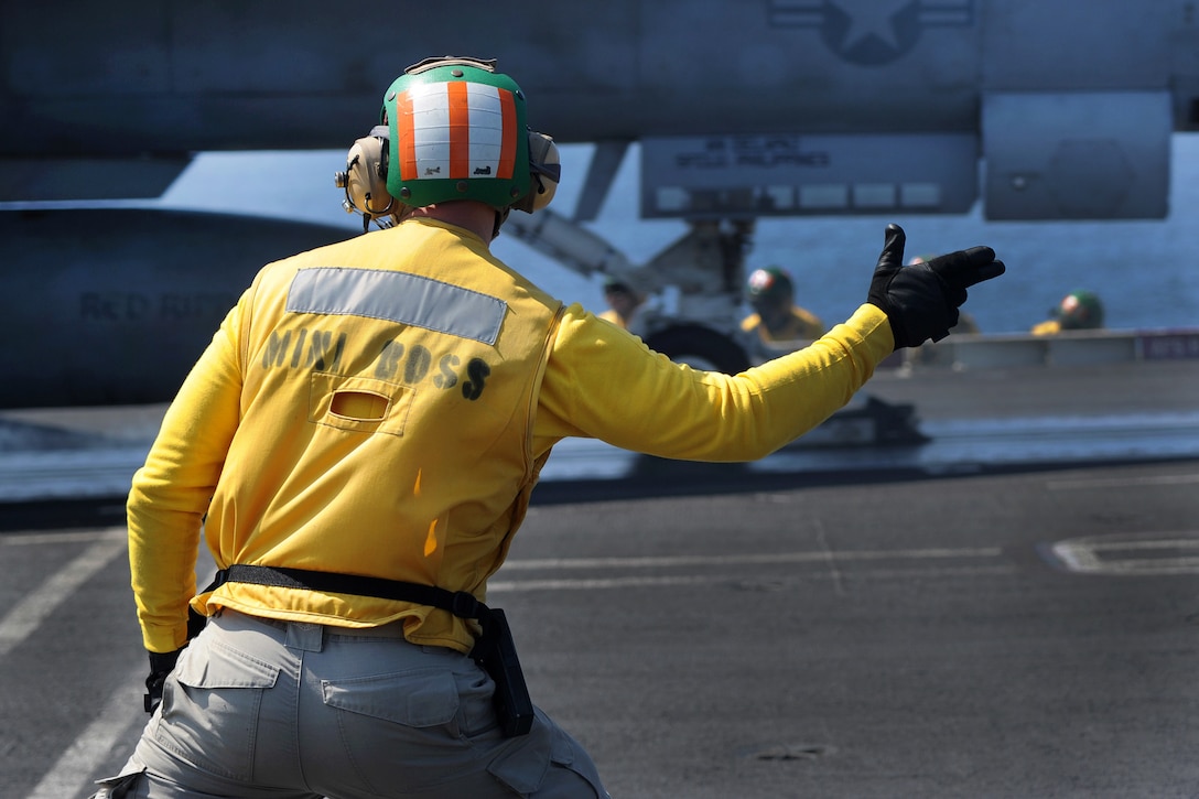 A sailor launches an F/A-18 Super Hornet from the USS Harry S. Truman.