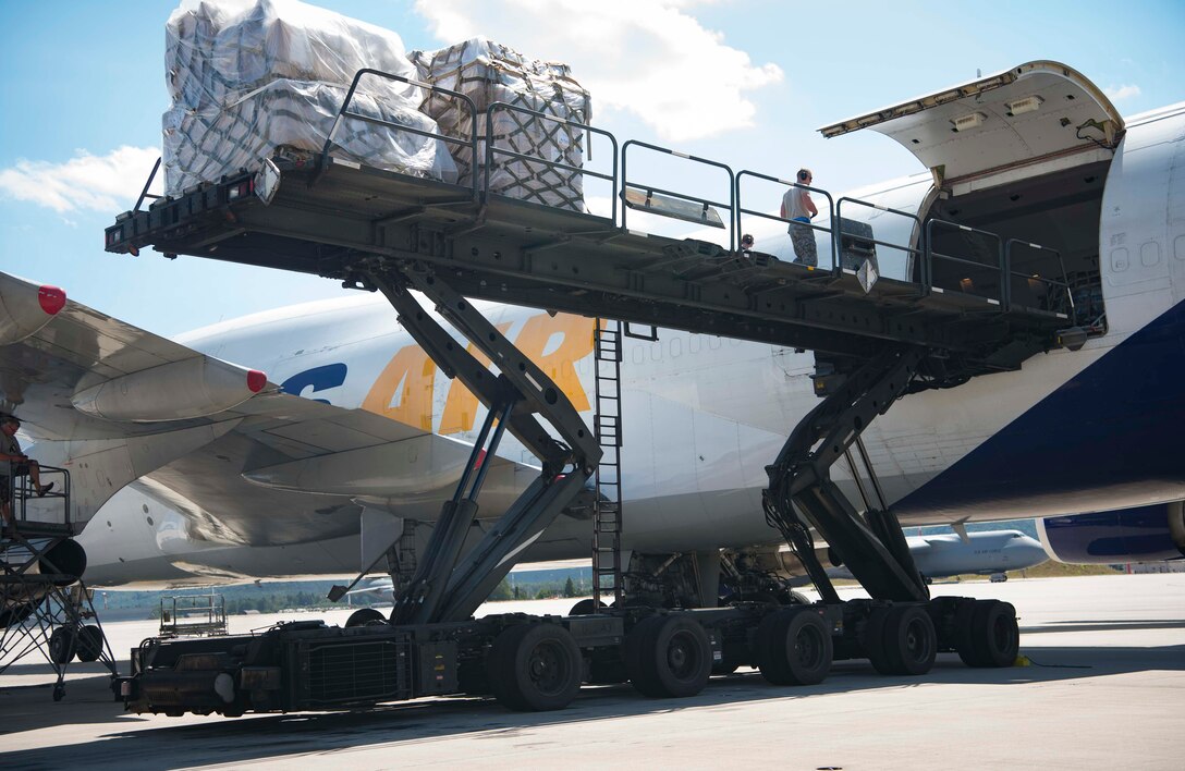 U.S. Airmen assigned to the 721st Aerial Port Squadron Ramp Services offload cargo from a Boeing 747 aircraft onto a K-loader on Ramstein Air Base, Germany, July 18, 2018. Ramp services delivers pallets to the cargo section, who breaks down the pallets and loads the contents for delivery to their final destination, ensuring Ramstein receives its mail, household goods, and supplies in a timely manner. (U.S. Air Force photo by Senior Airman Elizabeth Baker)
