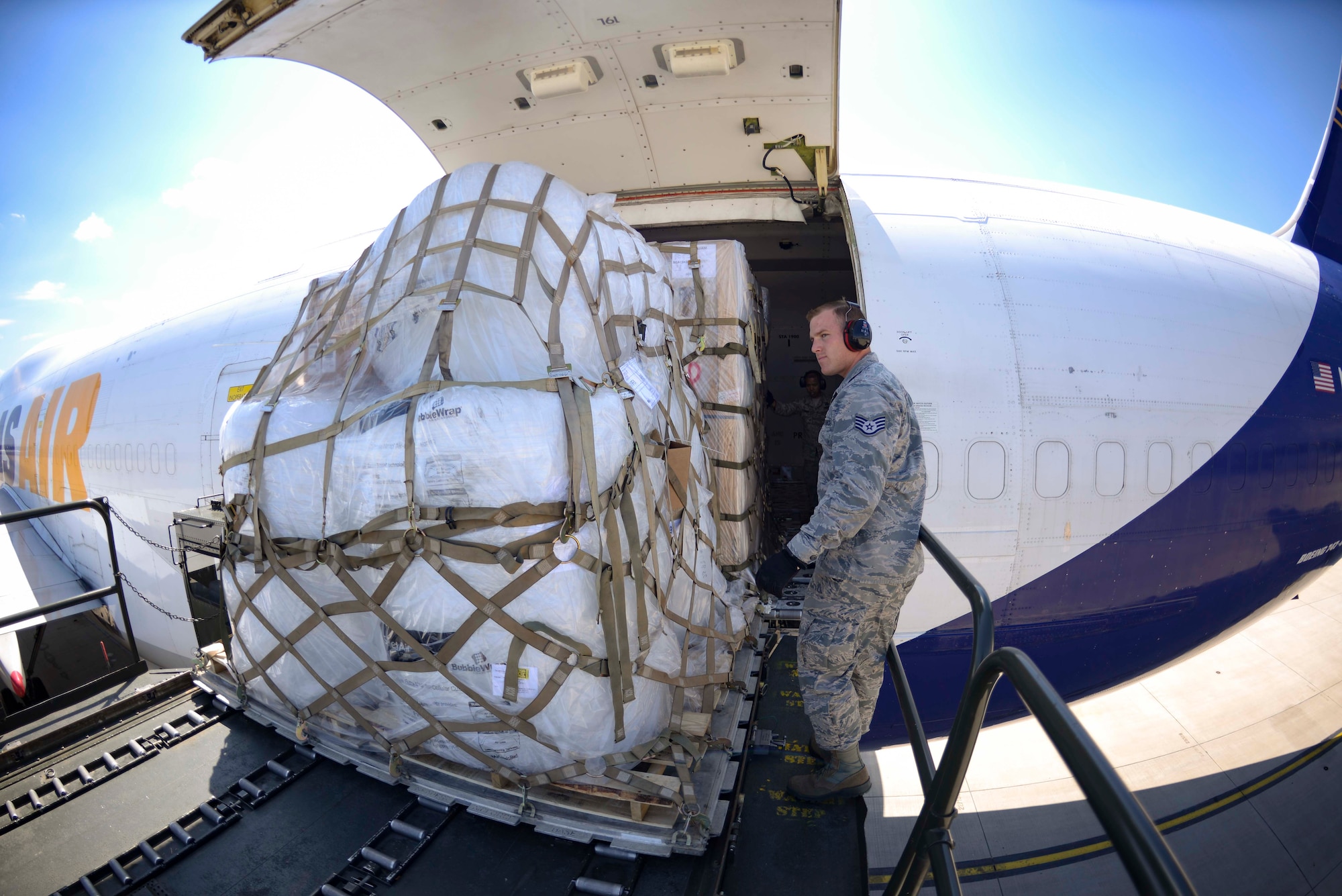 U.S. Air Force Staff Sgt. Brandon Mabee, 721st Aerial Port Squadron Ramp Services supervisor, assists with offloading cargo from a Boeing 747 aircraft on Ramstein Air Base, Germany, July 18, 2018. The 721st APS is composed of a variety of sections, including the Ramstein Passenger Terminal, which processes Ramstein's airborne passengers;  fleet services, which provides meals, cleaning, and servicing for aircraft; and the cargo section, which receives cargo pallets from ramp services and breaks them down for delivery to their final destinations. (U.S. Air Force photo by Senior Airman Elizabeth Baker)