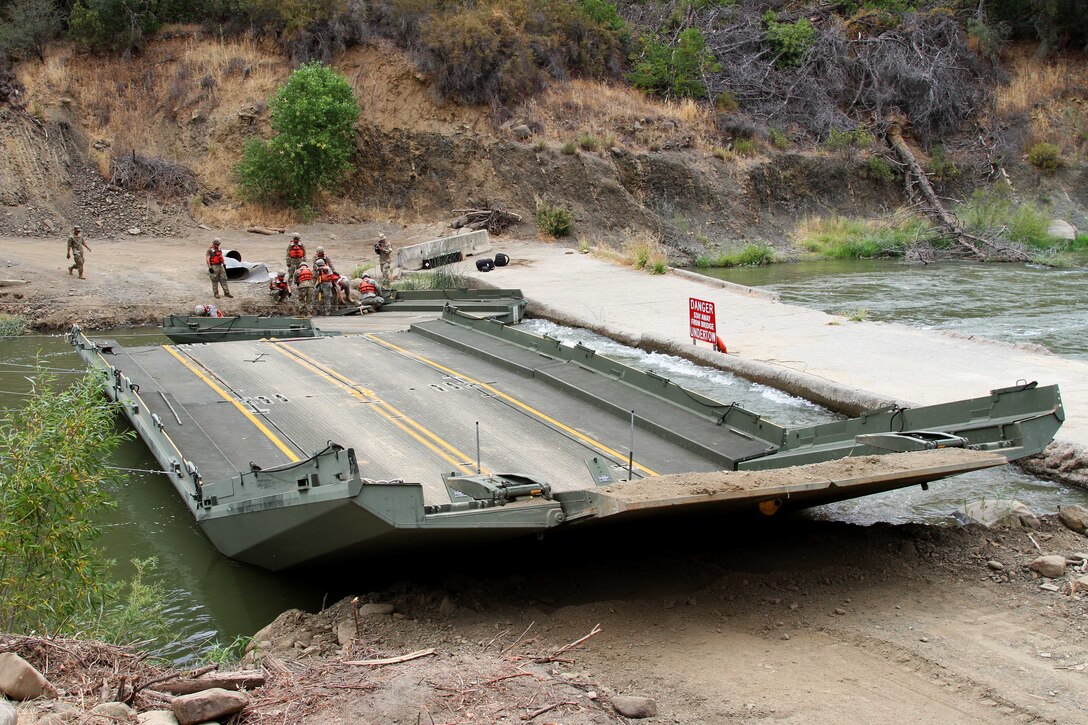 Soldiers work to dismantle a 100-foot temporary floating bridge.