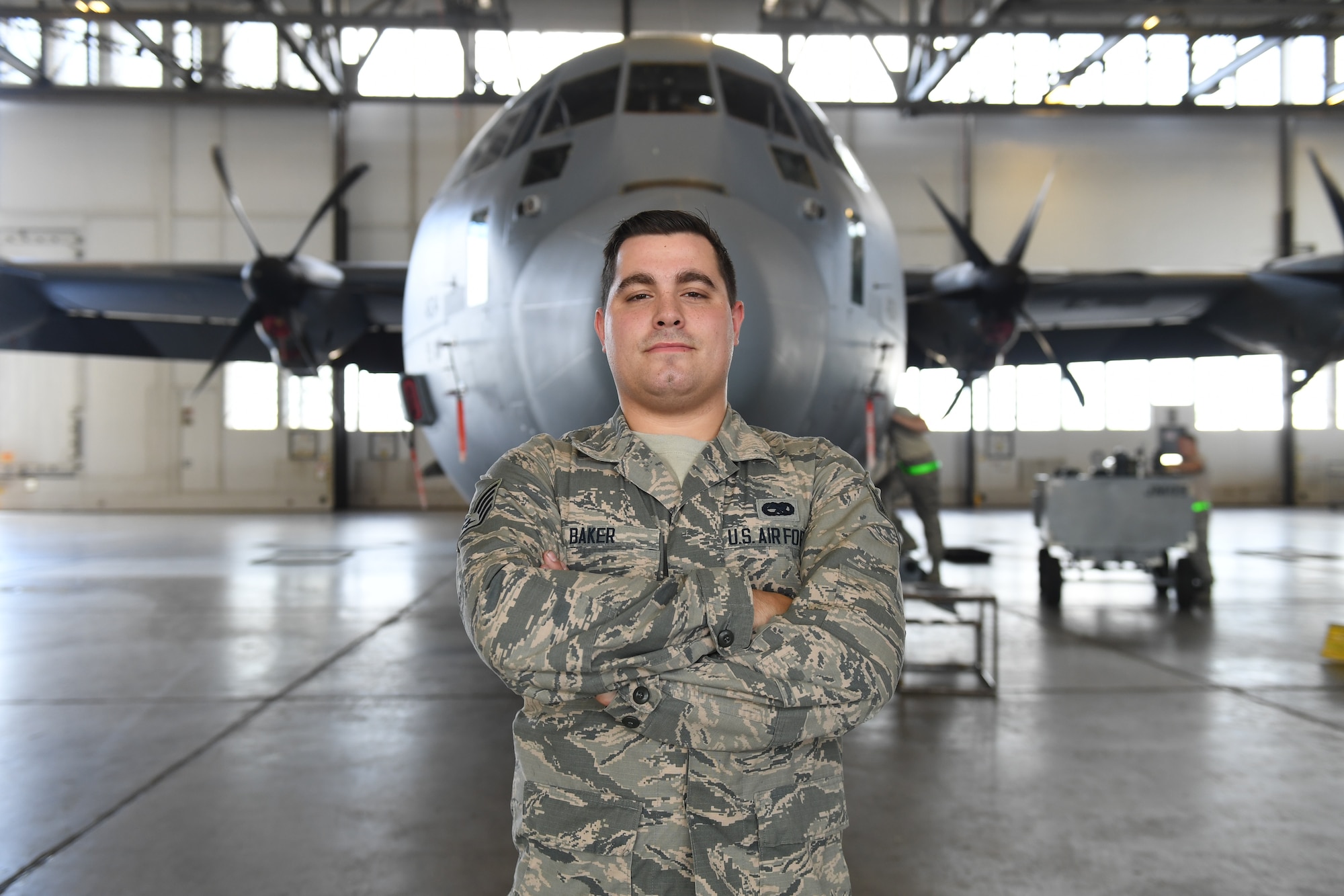 Man poses for photo in front of plane.