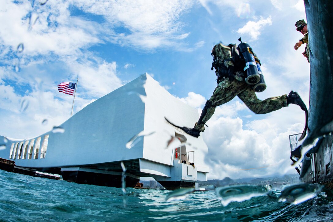 A sailor leaps into the water to conduct a training dive.