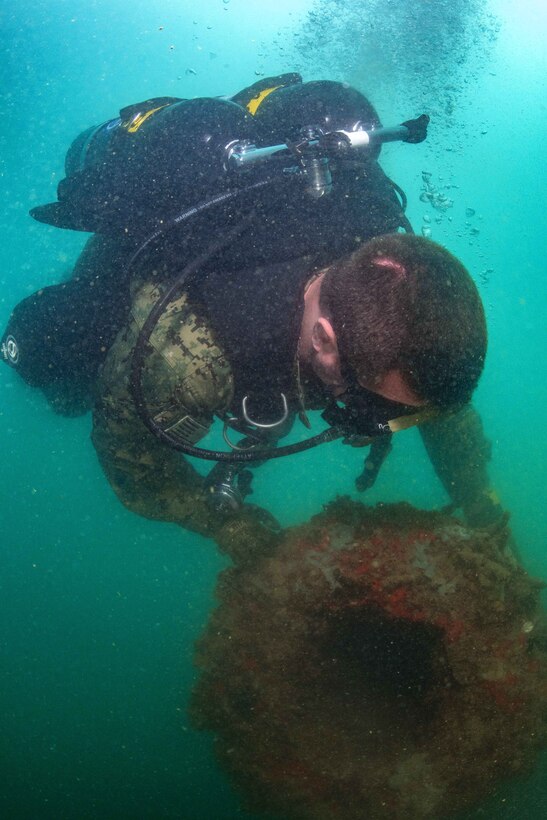 A sailor checks out an object while conducting a training dive mission.