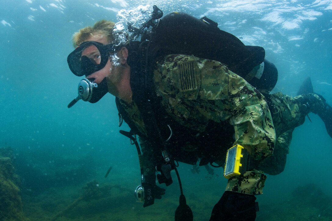 A sailor conducts a training dive mission on the USS Arizona Memorial.