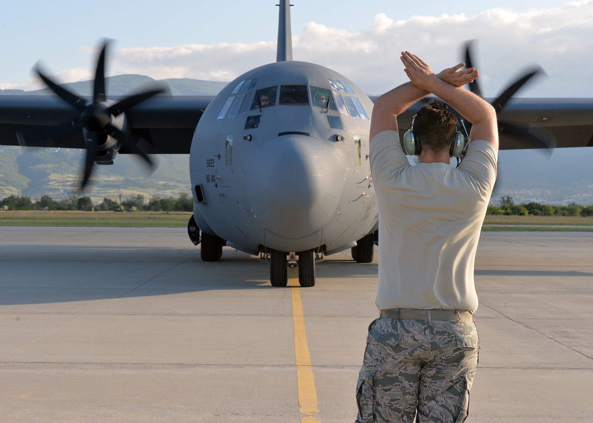 A U.S. Air Force Airman with the 86th Aircraft Maintenance Squadron marshalls a C-130J Super Hercules aircraft to its parking spot in Plovdiv, Bulgaria, July 22, 2018. During Thracian Summer, 37th Airlift Squadron pilots flew more than 120 hours during 48 sorties to meet objectives and build partnership capacity with Bulgarian partners. (U.S. Air Force Staff Sgt. Jimmie D. Pike)