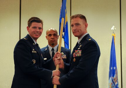 Maj. Joshua Aultman, right, 628th Communications Squadron outgoing commander, passes the 628th CS guidon to Col. Rockie Wilson, left, 628th Mission Support Group commander, during a change of command ceremony at the Charleston Club, July 29, 2018. The 628th CS plans, installs, operates and maintains the full spectrum of joint communications systems and knowledge management services, aiding in the successful mission execution of Joint Base Charleston.
