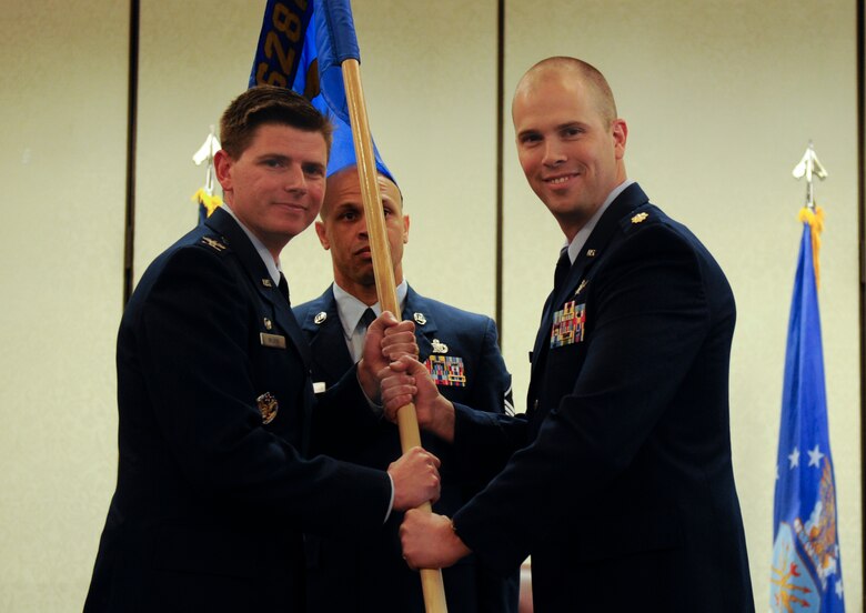 Maj. Andrew Mackenzie, right, 628th Communications Squadron incoming commander, accepts the 628th Mission Support Group guidon from Col. Rockie Wilson, left, 628th Mission Support Group commander, during a change of command ceremony at the Charleston Club, July 29, 2018. The 628th CS plans, installs, operates and maintains the full spectrum of joint communications systems and knowledge management services, aiding in the successful mission execution of Joint Base Charleston.