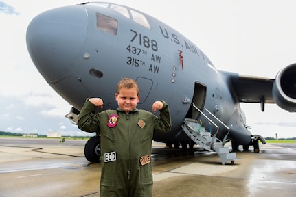 Caleb Pettit, 9, flexes his muscles in front of a C-17 Globemaster III, July 20, 2018, at Joint Base Charleston, S.C.