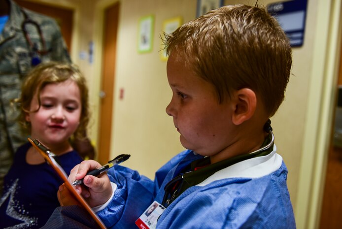 Caleb Pettit, 9, writes down the height and weight of a patient while playing doctor, July 20, 2018, at Joint Base Charleston, S.C.