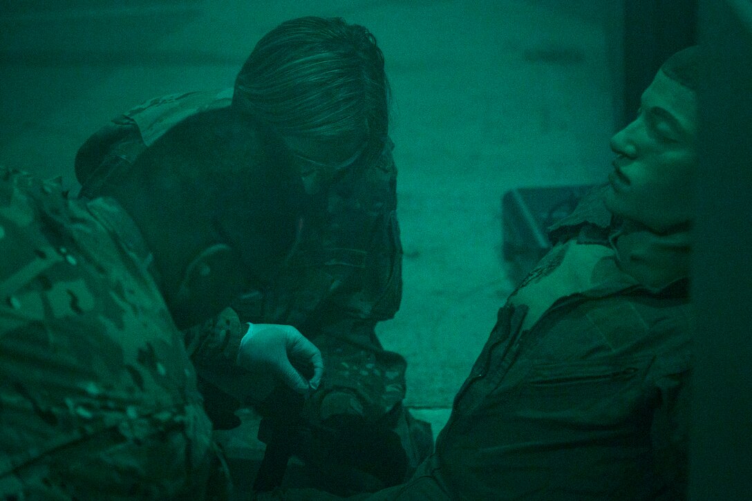 Col. Jennifer Short, center, 23d Wing commander, applies a combat application tourniquet on a simulated trauma victim during an immersion tour, July 23, 2018, at Moody Air Force Base, Ga. During the immersion, Short visited with Survival, Evasion, Resistance, Escape (SERE) and medical specialists from the 347th Operations Support Squadron (OSS). The 347th OSS rescue training center houses both independent duty medical technician paramedics and SERE specialists, whose mission is to train and equip Airmen to be able to survive and save lives while in austere environments. (U.S. Air Force photo by Airman 1st Class Erick Requadt)