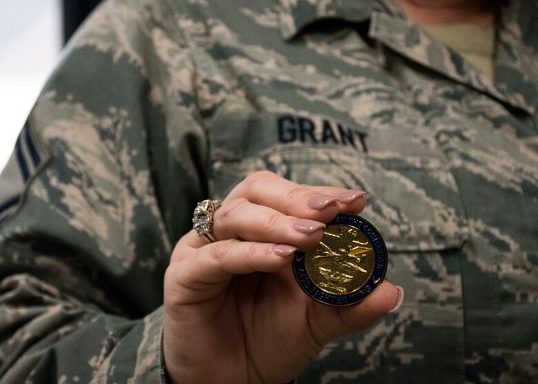 Senior Master Sgt. Rachel Grant holds a coin she received by the commander.