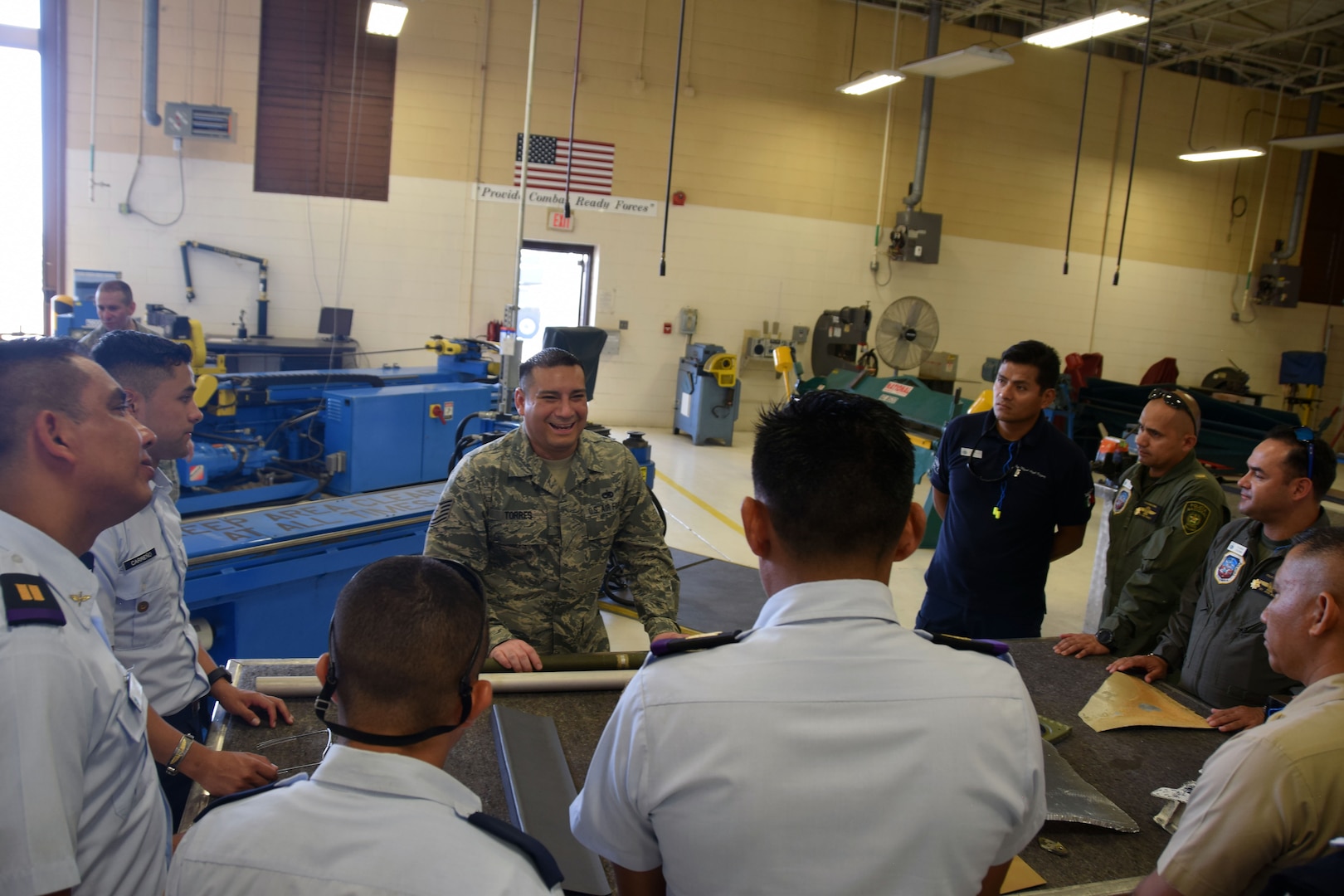 Tech. Sgt. Edgar Torres, 433rd Aircraft Maintenance Squadron sheet metal technician, explains to students from the Inter-American Air Forces Academy, how he repairs the metal on a C-5M Super Galaxy July 18 at Joint Base San Antonio-Lackland. Torres, who gave his briefing in Spanish, also explained how he fabricates parts for the aircraft at another area in his work station.