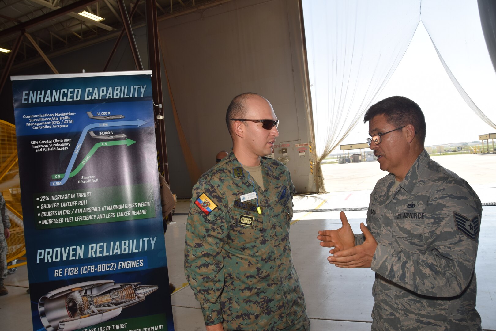 Tech. Sgt. William T. Holland, 433rd Maintenance Squadron jet engine mechanic, talks with 2nd Lt. Ivan Torres, an Ecuadorean Air Force maintenance officer, about the new GE CF6-80C2 turbofan engine the C-5M Super Galaxy aircraft uses July 18 at Joint Base San Antonio-Lackland. Inter-American Air Forces Academy students, like Torres, are from Latin American nations who study courses taught in Spanish in subjects ranging from professional military education, operations and support to aircraft and systems training.