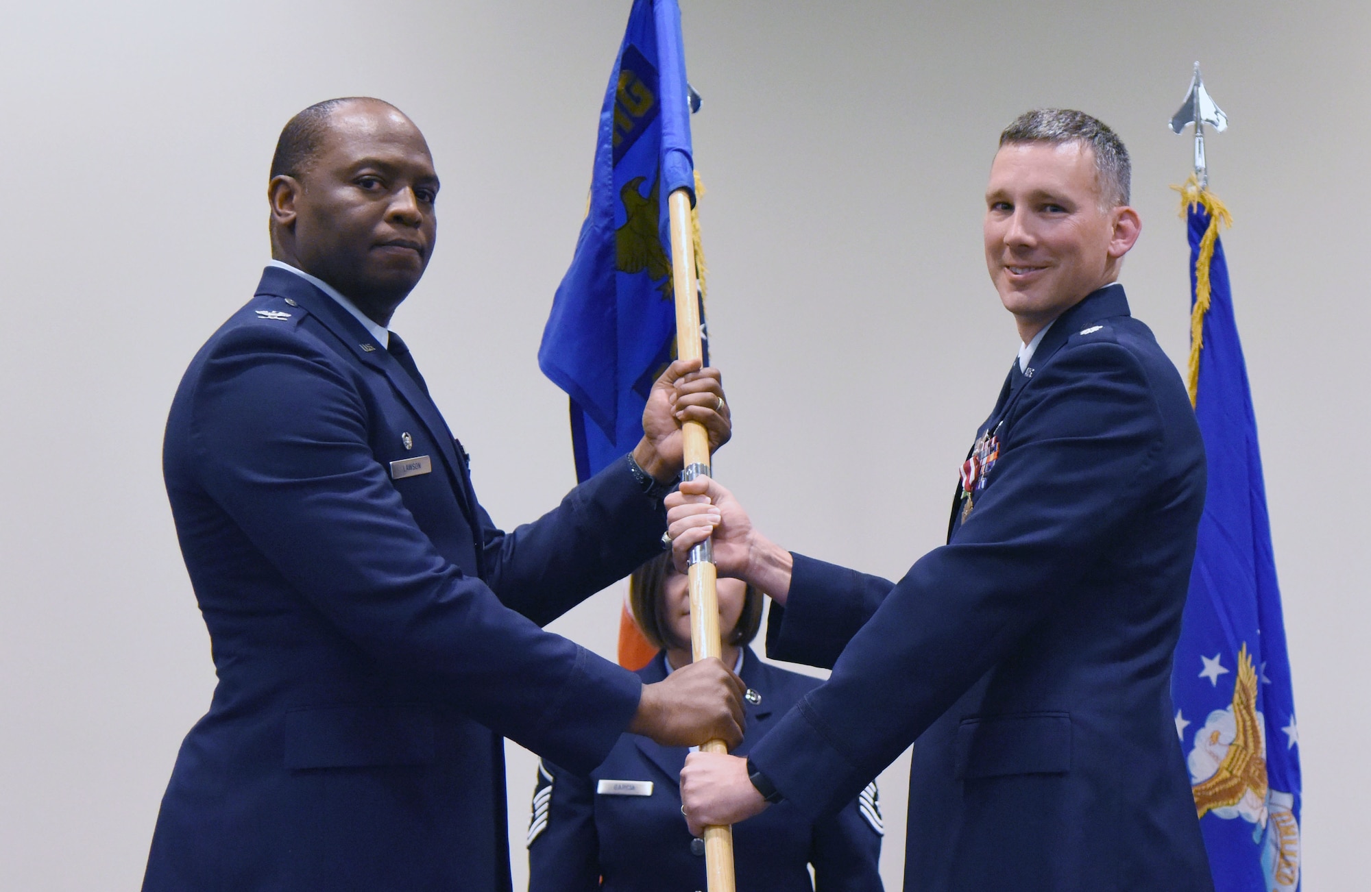 U.S. Air Force Col. Leo Lawson, Jr., 81st Training Group commander, takes the 336th Training Squadron guidon from Lt. Col. Daniel Schmitt, outgoing 336th TRS commander, during the 336th TRS change of command ceremony in the Roberts Consolidated Aircraft Maintenance Facility at Keesler Air Force Base, Mississippi, July 23, 2018. The passing of the guidon is a ceremonial symbol of exchanging command from one commander to another. (U.S. Air Force photo by Kemberly Groue)