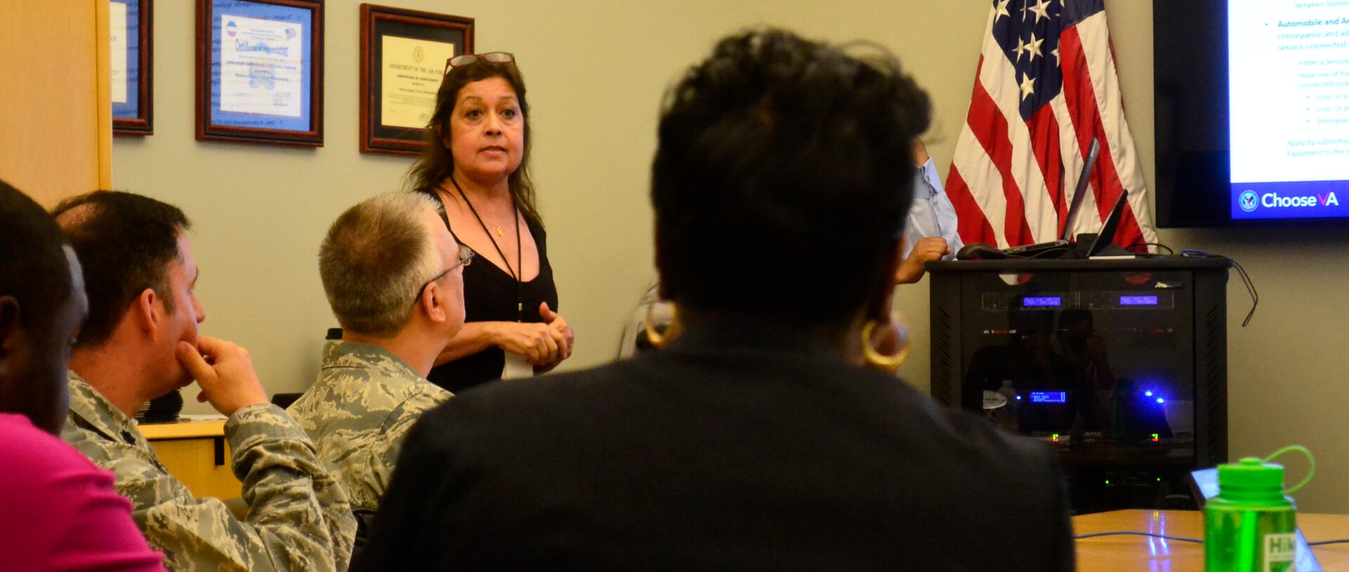 Maria Arroyo, from the Philadelphia Veterans Affairs Regional Office and Insurance Center, left center, briefs benefits information to Medical supply chain military and veteran employees at DLA Troop Support in Philadelphia, July 18, 2018.