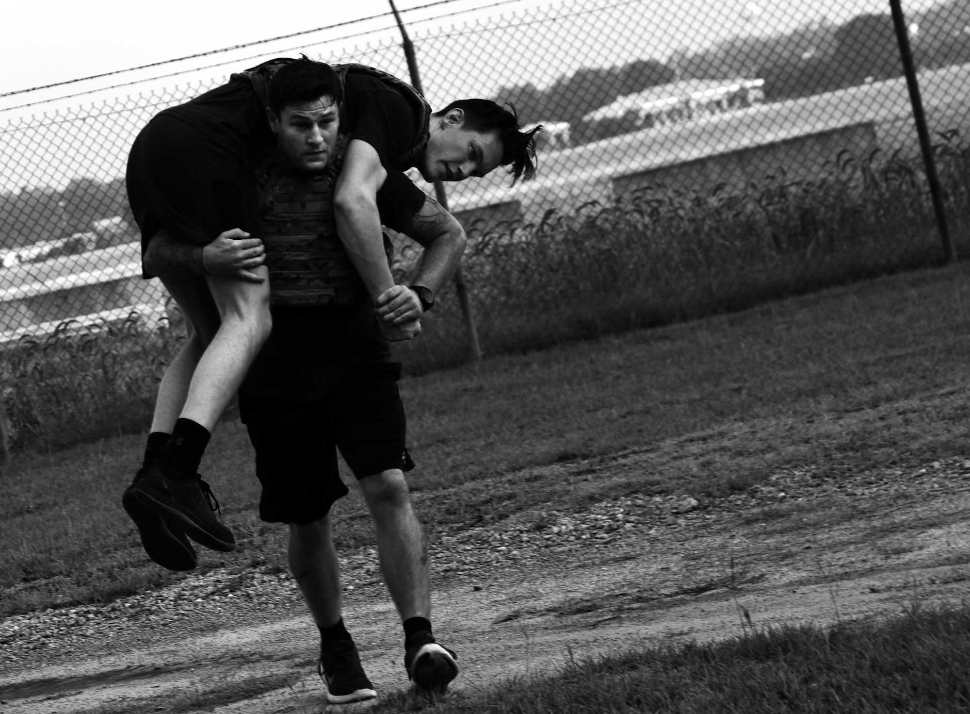 U.S. Air Force Staff Sgt. Jordan Massey, 20th Civil Engineer Squadron (CES) explosive ordnance disposal (EOD) craftsman, performs a fireman carry with Airman 1st Class Evan Cooling, 20th CES EOD apprentice, over his shoulders during physical training at Shaw Air Force Base, S.C., July 19, 2018.