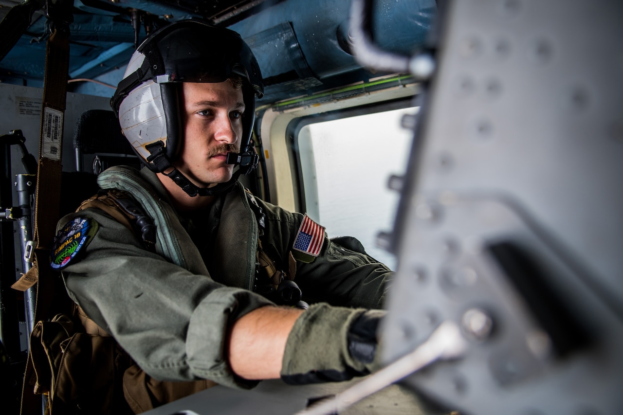 Navy Petty Officer 3rd Class Chad Wiltshire operates a console aboard an MH-60R Sea Hawk helicopter assigned to Helicopter Maritime Strike Squadron 35 during the Rim of the Pacific exercise in the Pacific Ocean.