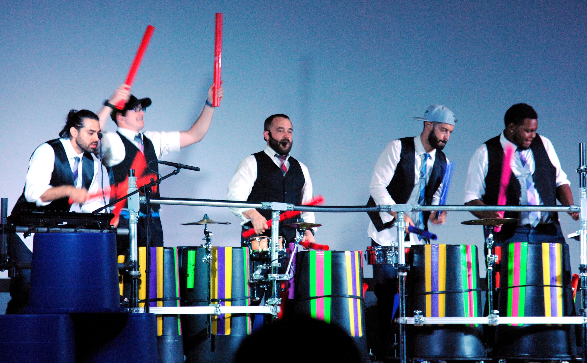 Jeremy Price (center), creator of Plastic Musik, and members of his band use boom whackers as musical instruments during a concert at the base theater here July 21. The band is on tour and has performed at several other Air Force bases along the way. (U.S. Air Force photo by Jessie Perkins)