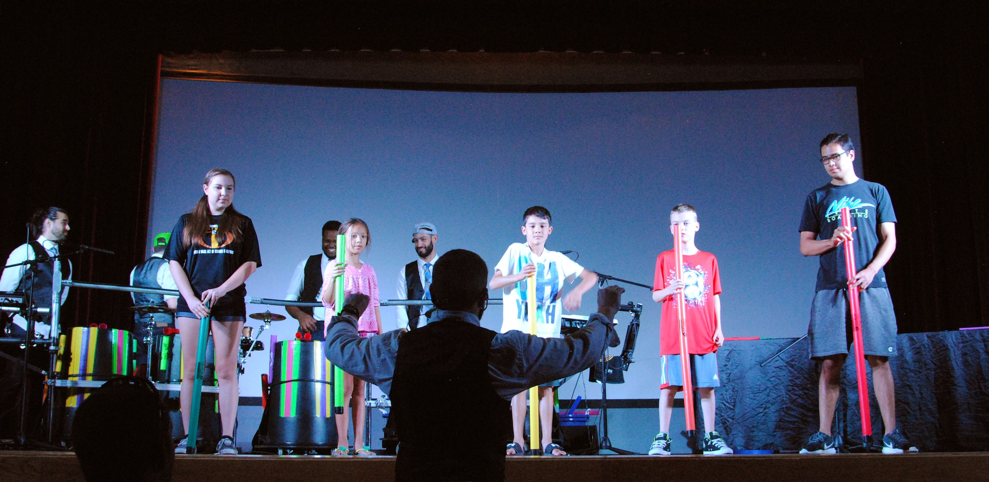 Jeremy Price (center), creator of Plastic Musik, and members of his band use boom whackers as musical instruments during a concert at the base theater here July 21. The band is on tour and has performed at several other Air Force bases along the way. (U.S. Air Force photo by Jessie Perkins)